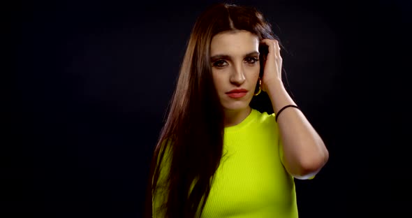 a Portrait of a Brunette with Long Hair, Red Lipstick on Her Lips and Large Gold Rings in Her Ears alt