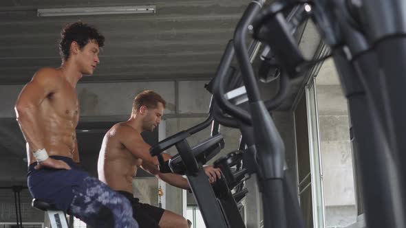 Athletic men cardio riding on bicycle at a fitness