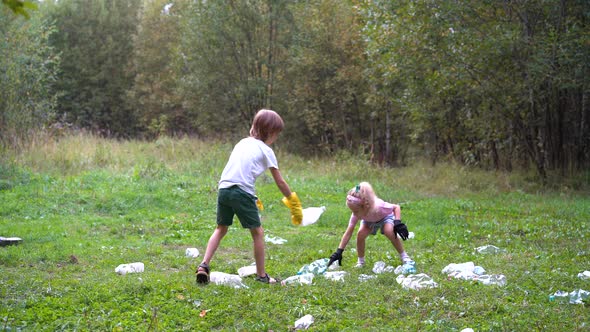 Children Remove Plastic Garbage and Put It in a Biodegradable Garbage Bag in the Open Air alt