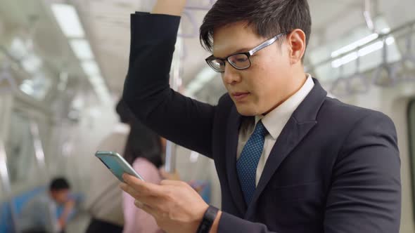 Businessman Using Mobile Phone on Public Train alt