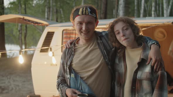 Portrait of Joyous Man and Woman Embracing at Campsite alt