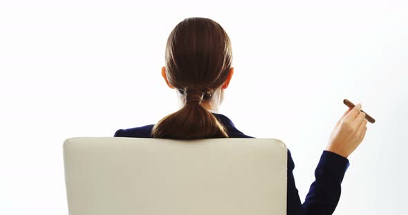 Businesswoman sitting and smoking cigar alt