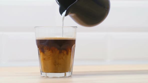Pouring Milk Into a Cup of Coffee