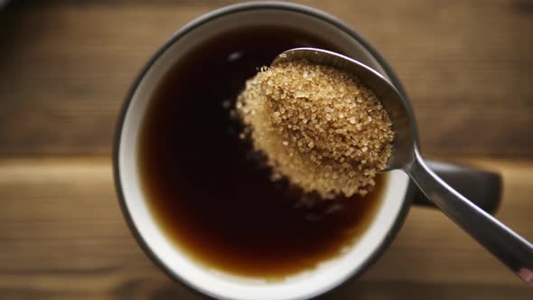 Pour Cane Sugar From Spoon Into Cup of Tea alt
