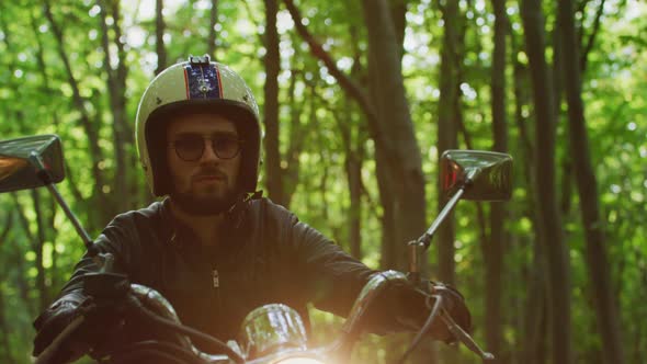 Riding a motorcycle near a forest alt