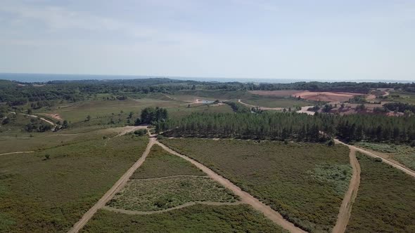 Flying over dirt road in Woodbury England. Sky view of land and nature in southwest England. alt