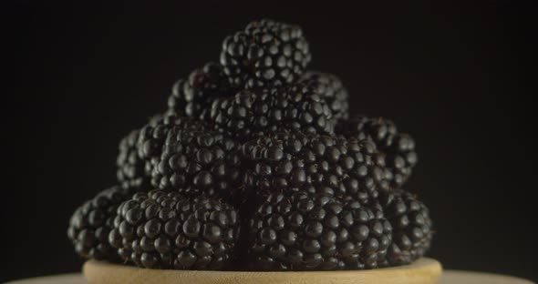 Ripe Blackberries on A Plate Rotate on A Black Background