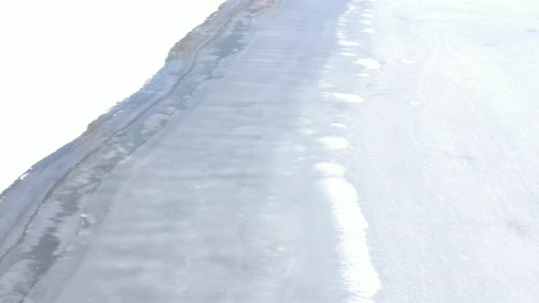 Above the ice  on lake surface by winter 4K aerial footage alt
