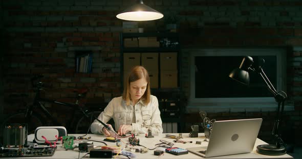Repair Woman Fixes or Assembles Electronic Circuit By Soldering in Loft Workshop