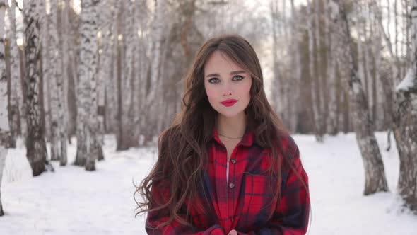 Charming Female with Long Hair Walking in Snowy Forest