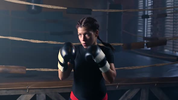 Female Boxer Training in the Dark Ring alt