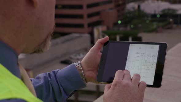 Construction supervisor looking at plans on digital tablet