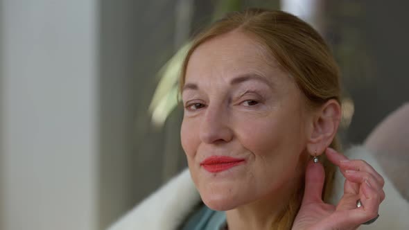 Headshot Portrait of Confident Smiling Rich Caucasian Middle Aged Woman Touching Expensive Earring alt