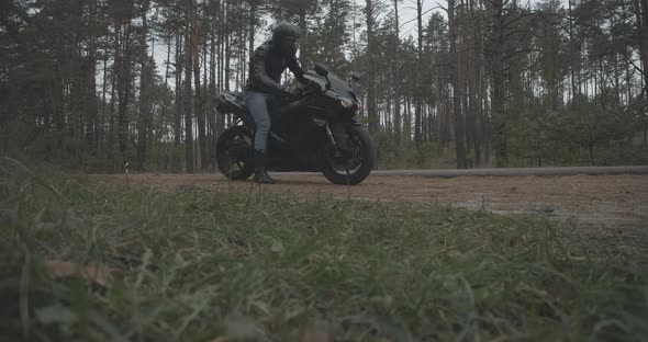 Wide Shot of Male Motorcyclist Turning on Engine and Leaving. Confident Young Man in Helmet and alt