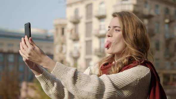 Pretty Girl Making Selfie Photo Outdoors, Funny Woman Using Cellphone on Street alt