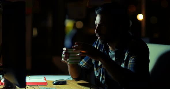 Business executive having coffee while working on computer alt