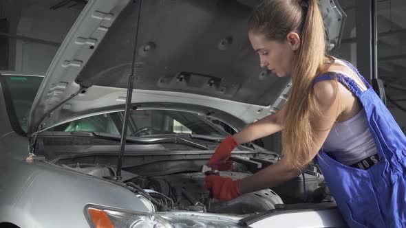 Experienced Mechanic Spinning with the Help of a Tool the Engine From an Auto Mechanic Is Repairing alt