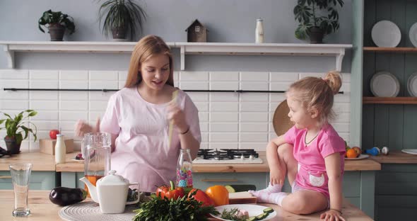 Beautiful Mother Cooking Dinner on Kitchen with Little Kid