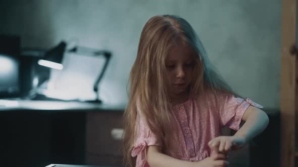 Adorable Little Girl Tries to Open Drug Bottle at Table alt
