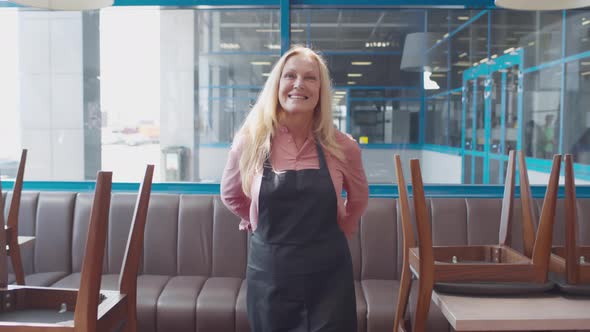 Mature Cafe Owner Put on Apron and Smile at Camera Walking alt