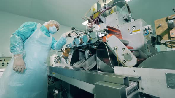 Pharmacology Worker Is Checking Up a Transporting Machine alt