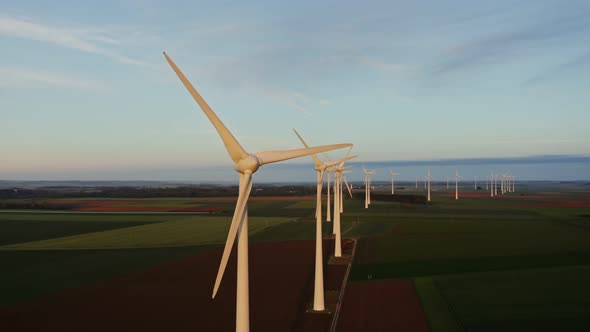 Horizontal Panning From a Drone View of a Massive Wind Farm Among Green Fields alt