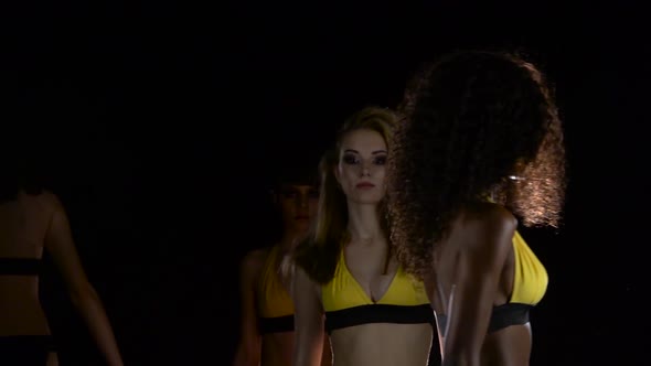 Fashion Shows in a Swimsuit. Black Background. Slow Motion alt