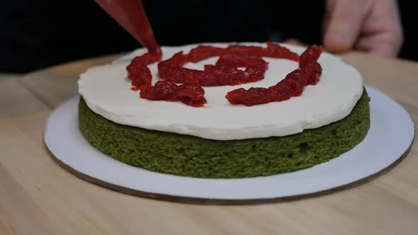 Pastry Chef Applies Berry Red Jam to Spinach Biscuit with Cream