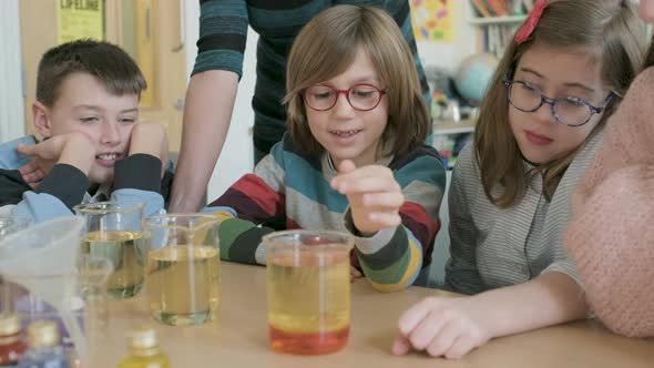 Children in a science lesson with a teacher alt