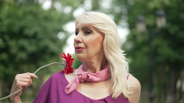 Adult Beautiful Woman with Red Flower Posing in Summer Park Outdoors alt