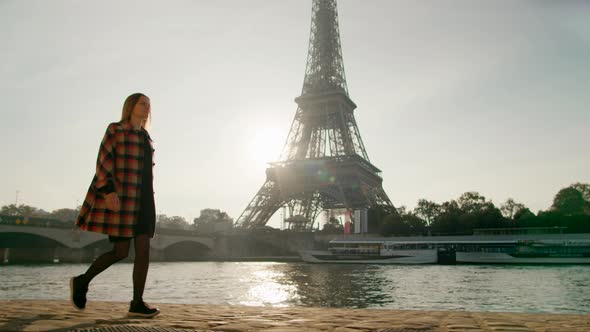 Woman in Casual Coat Walks in Paris France with Eiffel Tower at Background
