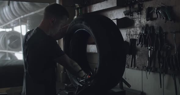 Mechanic Skiving the Tire Patch in Auto Service alt