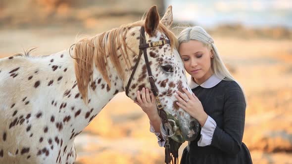 Slow Motion Young Blonde Woman Stroking And Hugging White Horse