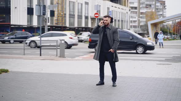 Street style. Man in an elegant black suit and gray coat alt