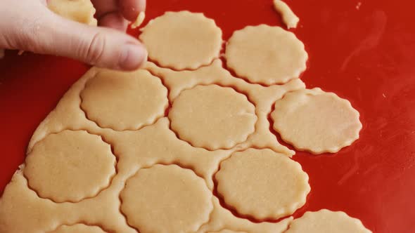 Close Up Woman Hand Making Cookies in the Round Shape on the Red Silicone Baking Mat alt
