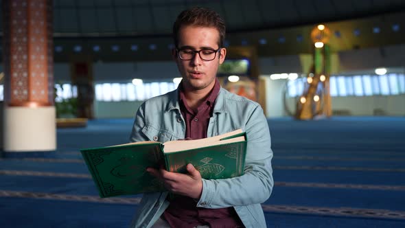 Young University Student Reading Quran in Mosque alt