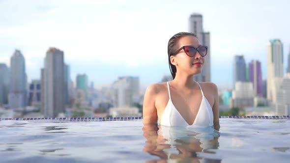 Young asian woman enjoy around outdoor swimming pool for leisure alt