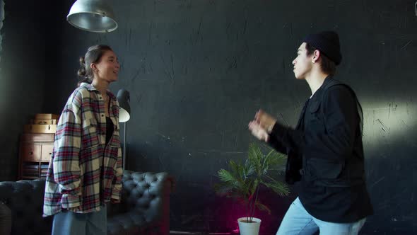 Stylish Boy and Girl Dancing Hiphop on Black Background at Dance Hall alt