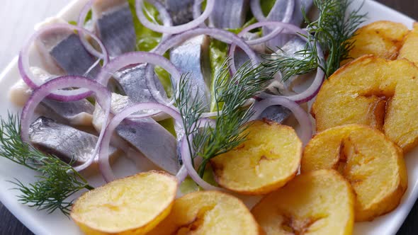Herring Fish Served with Potatoes and Onion on White Plate alt