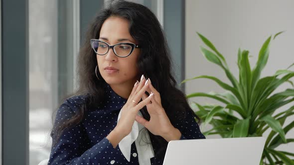 Thoughtful concerned mixed race woman working on laptop computer alt