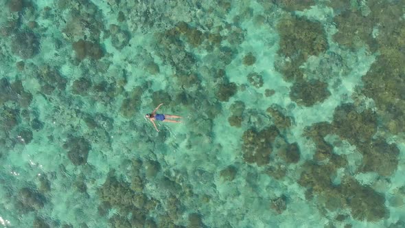 Aerial: woman snorkeling on coral reef tropical caribbean sea turquoise water In alt