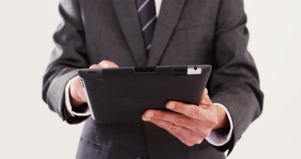 Mid-section of businessman using digital tablet alt