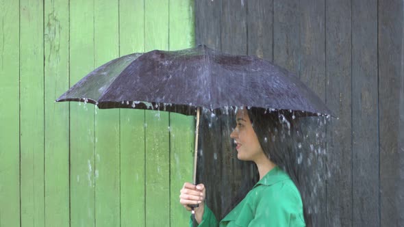 Heavy Rain pours on Girl Sheltered under Umbrella