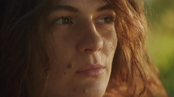 Handheld Close Up Catching Sunbeam on Curly Caucasian Woman Face with Freckles and Birthmarks alt