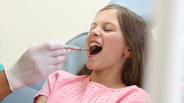 Close up of cute girl having a dental checkup with mouth mirror alt