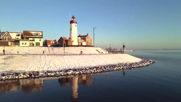 Urk Netherlands Lighthouse During Winter with Snow Covered Coastline Urk View at the Lighthouse alt