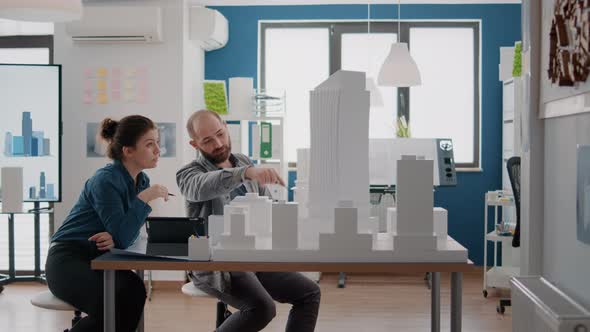 Workmates Looking at Tablet and Building Model to Get Inspiration for Urban Project alt