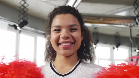 Young Hispanic girl with pom-poms