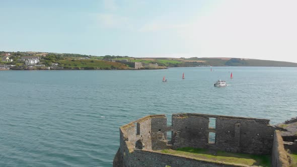 Derelict watchtower in foreground of this harbor scene tourists return from a guided boat trip & sai alt