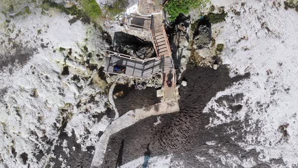 The Rock Restaurant in Ocean Built on Cliff at Low Tide on Zanzibar Aerial Top alt